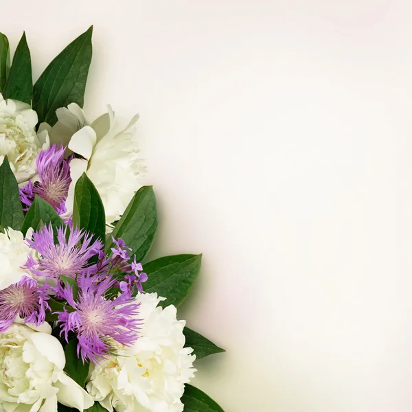 Peony and wild flowers bouquet with notepad