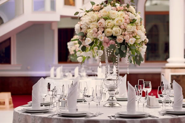 Table setting at a luxury wedding reception. Beautiful flowers on the table.