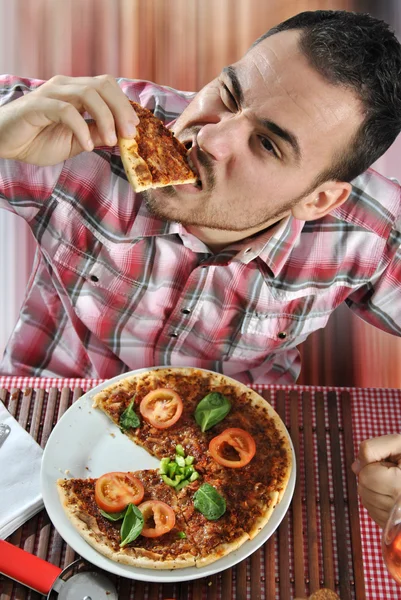 Crazy hungry man eating pizza