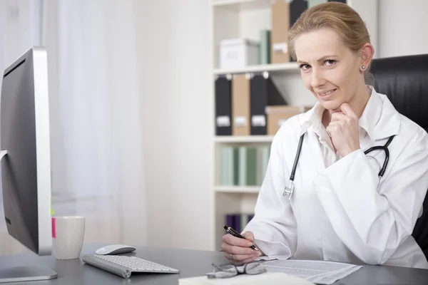 Female Physician on her Table Writing Reports