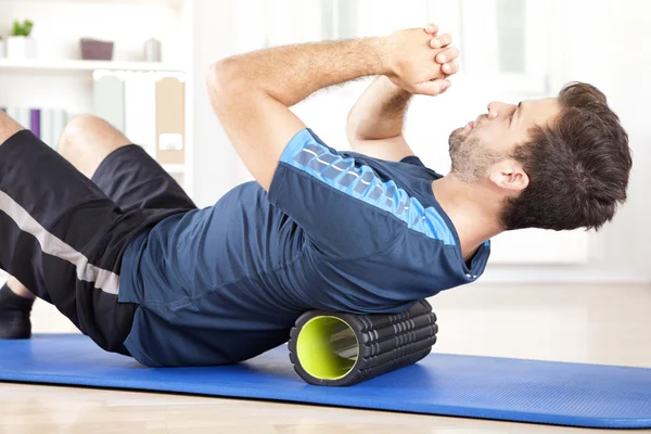 Man Lying on a Foam Roller While Doing an Exercise