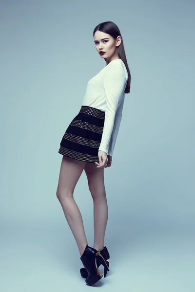 High fashion portrait of young elegant woman in black skirt and