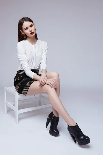 High fashion portrait of young elegant woman in black skirt and