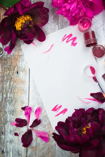 Workspace. Watercolor, paintbrush and pink peonies isolated on white background. Overhead view. Flat lay, top view