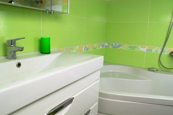 Green bathroom interior. Corner bath