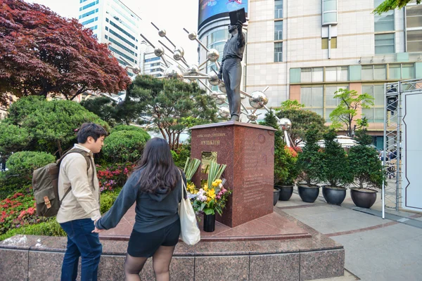 People looking at the monument in downtown Seoul