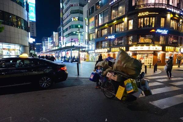 A man with a cart cross the street in Seoul