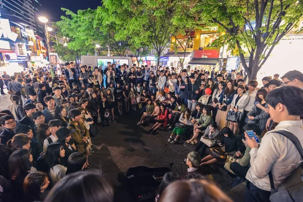 Young people surrounded a local musician In Hungdae district in Seoul, Korea