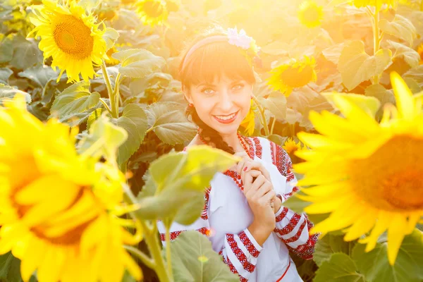 Pretty young woman embrodery on a sunflower plant