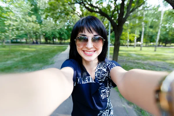 Attractive brunette woman makes selfie photos looking to camera