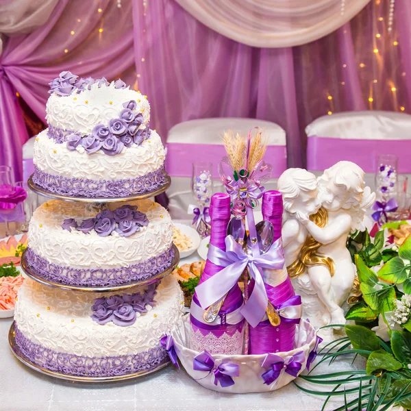 Cake and two bottles of wine on a decorated wedding table