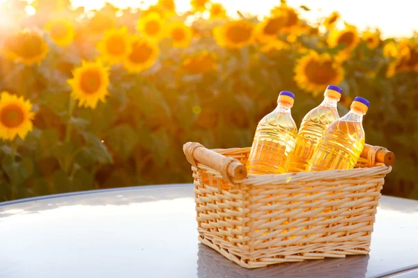 Three bottles of sunflower oil in a wicker basket in the sunset