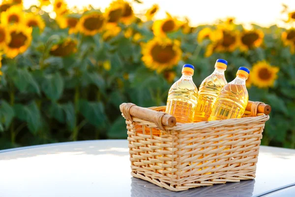 Three bottles of sunflower oil in a wicker basket on the backgro