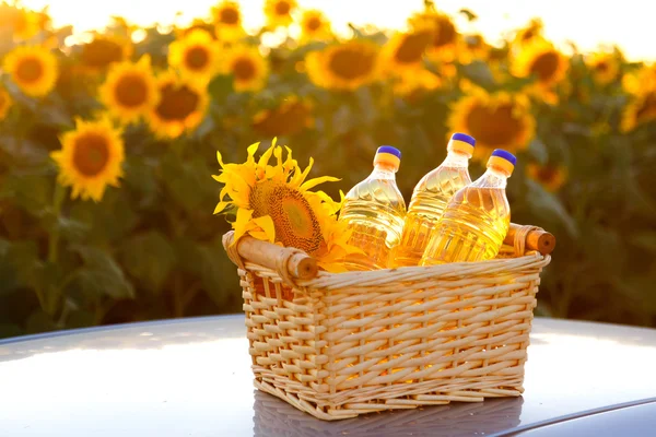 Three bottles of sunflower oil in a wicker basket against backli