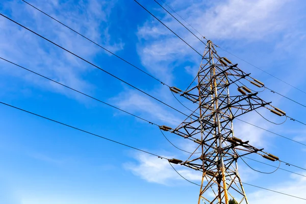 Electrical high voltage tower on a blue sky background