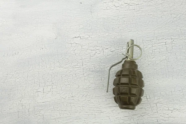 Hand grenade on shadowed, cracked background. War game. Sales of weapons.
