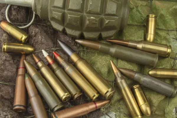 Different types of ammunition on a camouflage background. Preparing for war. Possession of weapons.