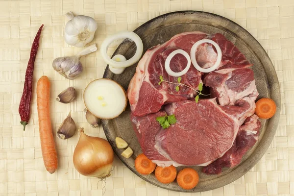 Raw beef shin and vegetables. Sales of beef. Preparing meat for cooking. Raw meat on a cutting board ready for cutting. Preparing the menu.