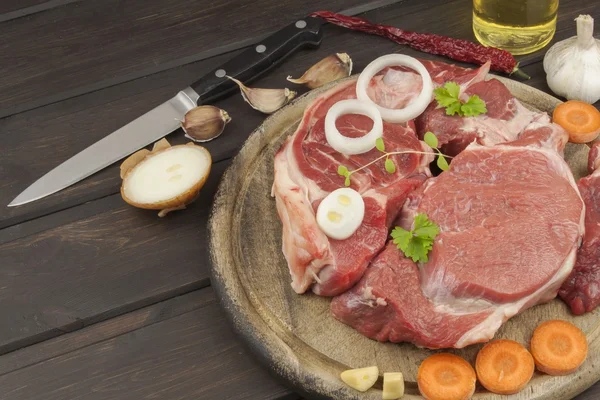 Raw beef shin and vegetables. Sales of beef. Preparing meat for cooking. Raw meat on a cutting board ready for cutting. Preparing the menu.