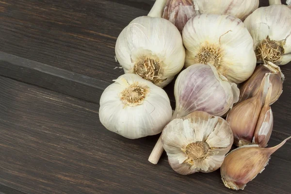 Fresh garlic on a wooden background. Traditional aromatic ingredients in food. Prevention against bad colds and flu.