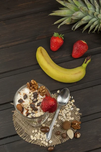 Preparing healthy breakfast for kids. Yogurt with oatmeal, fruit, nuts and chocolate. Oatmeal for breakfast. Preparing diet meals. A healthy diet for athletes.