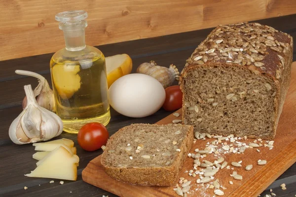 Freshly baked whole wheat bread. Preparing homemade breakfast. Various ingredients for the meal. Sliced bread on cutting board. Advertising on the bakery.