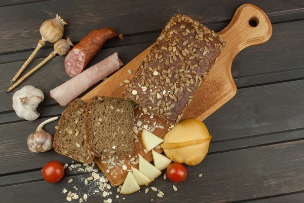 Freshly baked whole wheat bread. Preparing homemade breakfast. Various ingredients for the meal. Sliced bread on cutting board. Advertising on the bakery.