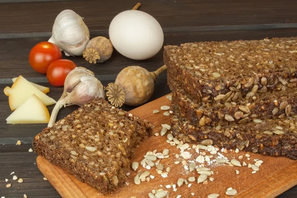 Freshly baked whole wheat bread. Preparing homemade breakfast. Various ingredients for the meal. Sliced bread on cutting board. Advertising on the bakery.