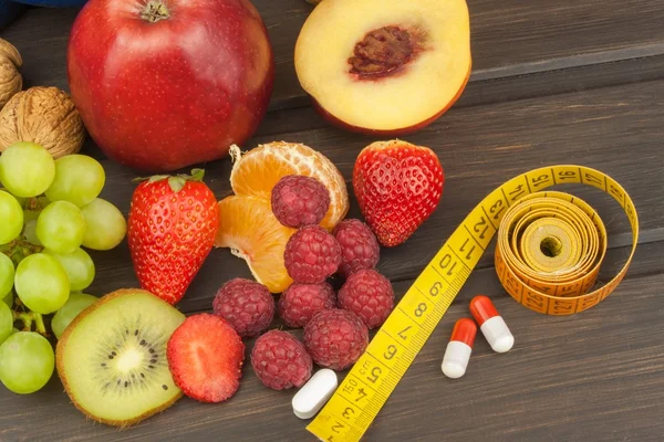 Healthy weight loss. Fruit, vitamins and sport. The concept of dietary supplements.