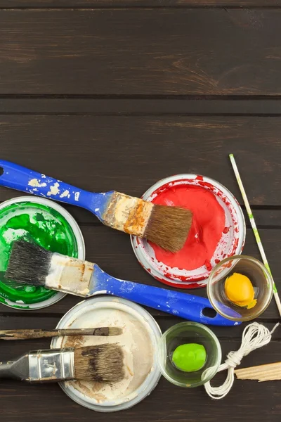 Brushes and paint on a wooden table. Painter tools. Workshop painter. Needs painting. Sales painting needs. Clutter on the workbench. Sales of color. Advertising on painting.