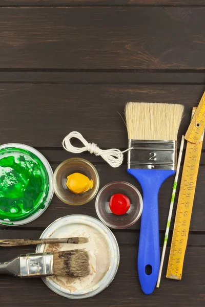 Brushes and paint on a wooden table. Painter tools. Workshop painter. Needs painting. Sales painting needs. Clutter on the workbench. Sales of color. Advertising on painting.