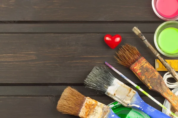 Brushes and paint on a wooden table. Painter tools. Workshop painter. Needs painting. Sales painting needs. Clutter on the workbench. Sales of color. Advertising on painting.