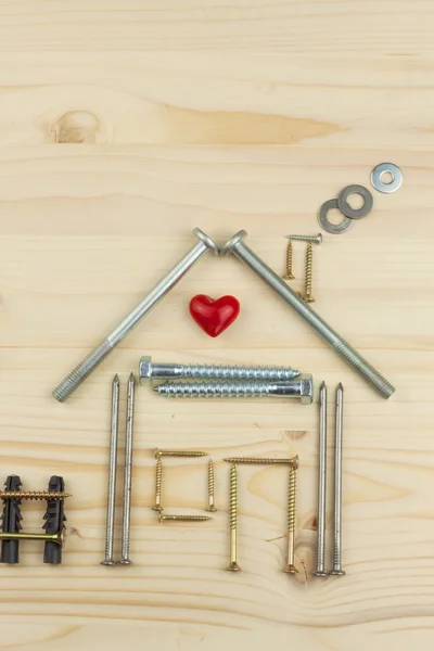 Building a house for the family. Plans to build a small house. Architect designing a house for a young family. House from nails and screws. Needed for building. Ideas about building a house.