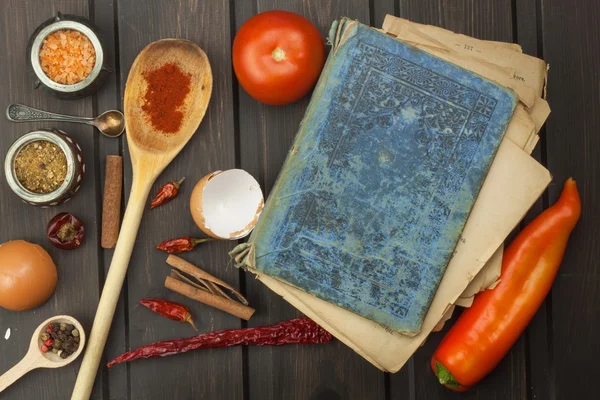 Recipe book and vegetables. Chili pepper and tomatoes. Food preparation according to the old recipe book. Grandma\'s recipe book. Old recipes for cooking.