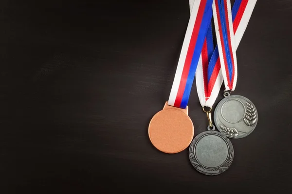 Sports medals on a wooden background. Collection of medals for the winners. Awards in sports.