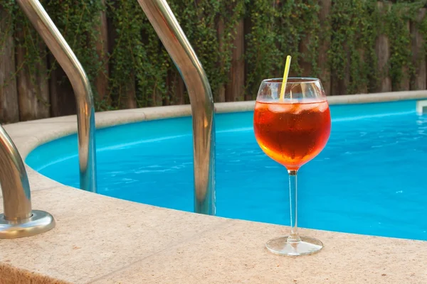 Cold summer drink by the pool. Party with refreshments by the pool. Alcohol drink with ice. Glasses with a refreshing drink. Alcohol at the party.