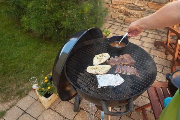 Grilled pork ribs on the grill. Marinated Grilled ribs on a summer party. Evening at a party.