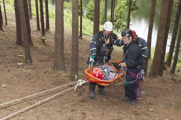 Pnovany, Czech Republic, June 4, 2014: training rescue injured people in difficult terrain at the dam, carrying a stretcher with an injured person