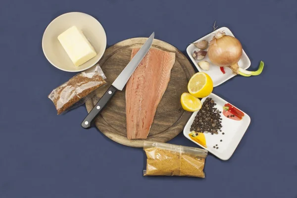 Preparation of frozen salmon, homemade dressing, salmon on a wooden chopping board
