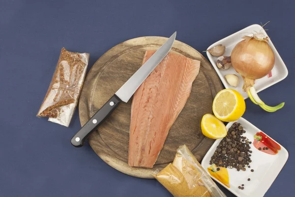 Preparation of frozen salmon, homemade dressing, salmon on a wooden chopping board