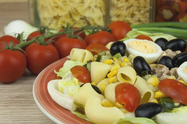 Refreshing summer dish, pasta with tuna, vegetables, olives and egg. Healthy food for athletes.