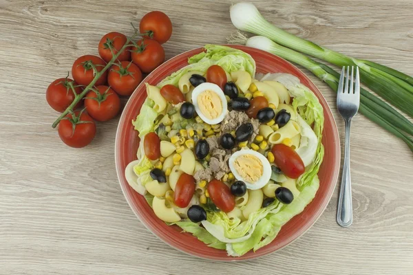 Refreshing summer dish, pasta with tuna, vegetables, olives and egg. Healthy food for athletes.