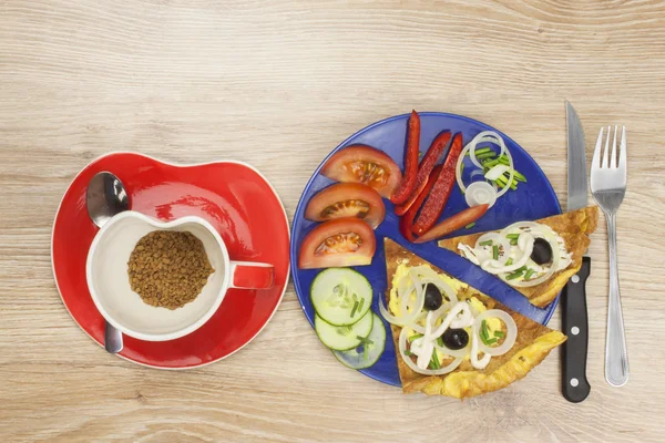 Preparing a delicious dinner. Scrambled egg omelet with vegetables on a wooden table. Preparation of fast food home.