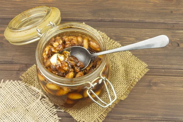 Jar of honey and nuts. Sweet treat for snacking. Pickled walnuts in honey. The ingredients for the sweet taste of dessert.