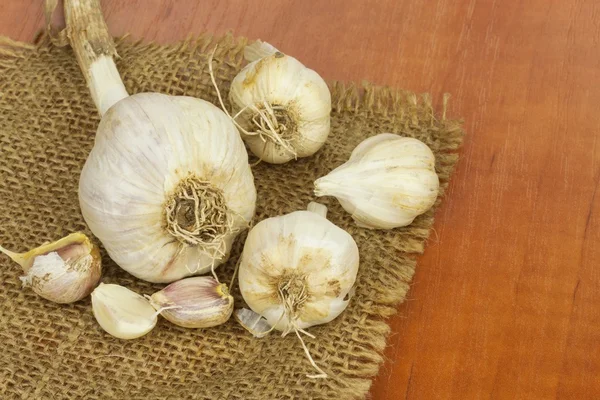 Homemade garlic grown in the garden. Traditional medicine against colds and flu. Strongly aromatic vegetables for cooking. Healthy ingredients for cooks. Garlic cloves on a wooden kitchen table.