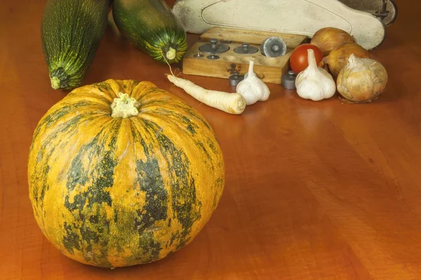 Growing vegetables in the organic farm. Vegetables grown in a small home garden. Old metal weight on homemade food. Background with vegetables. Promotion of healthy diets, diet food preparation.