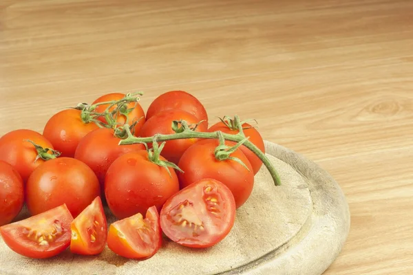 Fresh tomatoes on the kitchen table. Tomatoes on a wooden cutting board. Domestic cultivation of vegetables. Fresh organic food ready to cook. Fresh dietary ingredients. Raw vegetables to raw food.