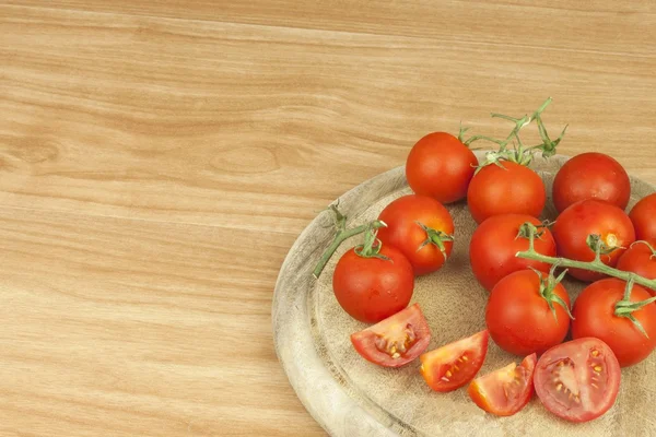 Fresh tomatoes on the kitchen table. Tomatoes on a wooden cutting board. Domestic cultivation of vegetables. Fresh organic food ready to cook. Fresh dietary ingredients. Raw vegetables to raw food.