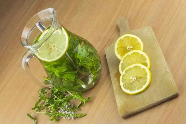 Fresh homemade mint tea. Tempting summer refreshment. Healthy, refreshing drink without sugar. Peppermint tea in a glass jar with lemon. Preparing tea.