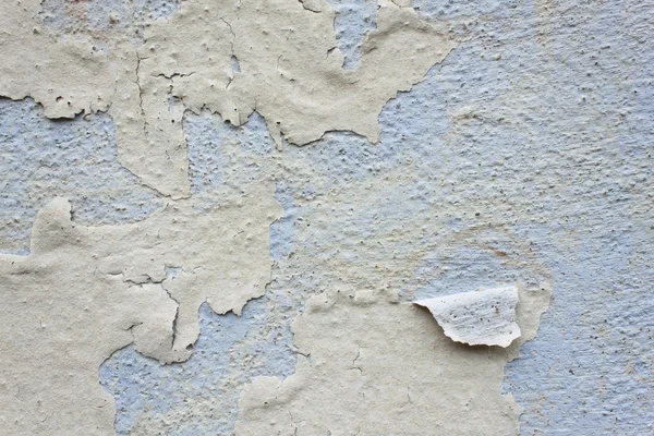 Cracked old Wall Detail Background Texture For Text Or Image. Abstract background, old cracked plaster wall, blue texture, paint stains and cracks. The impact of weather on outdoor facade.  Old paint